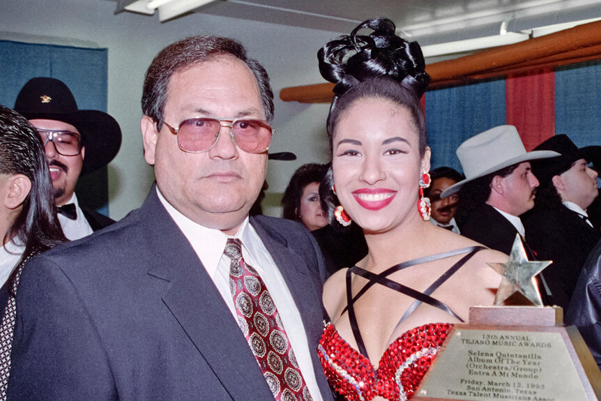Abraham and Selena Quintanilla pose together with an award