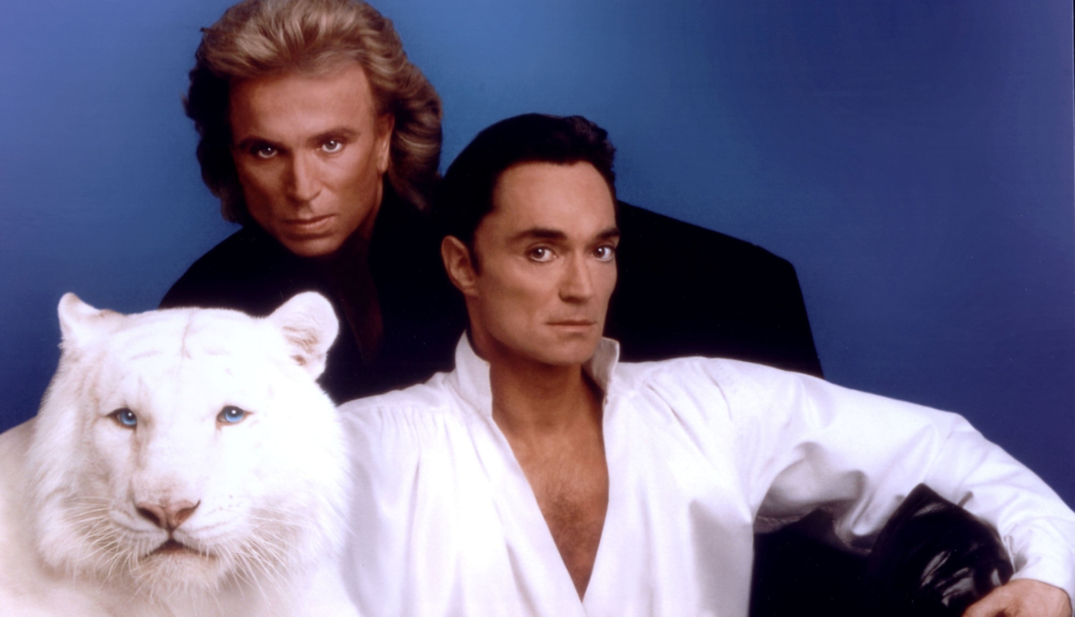 Siegfried Fischbacher and Roy Horn posing with a white tiger