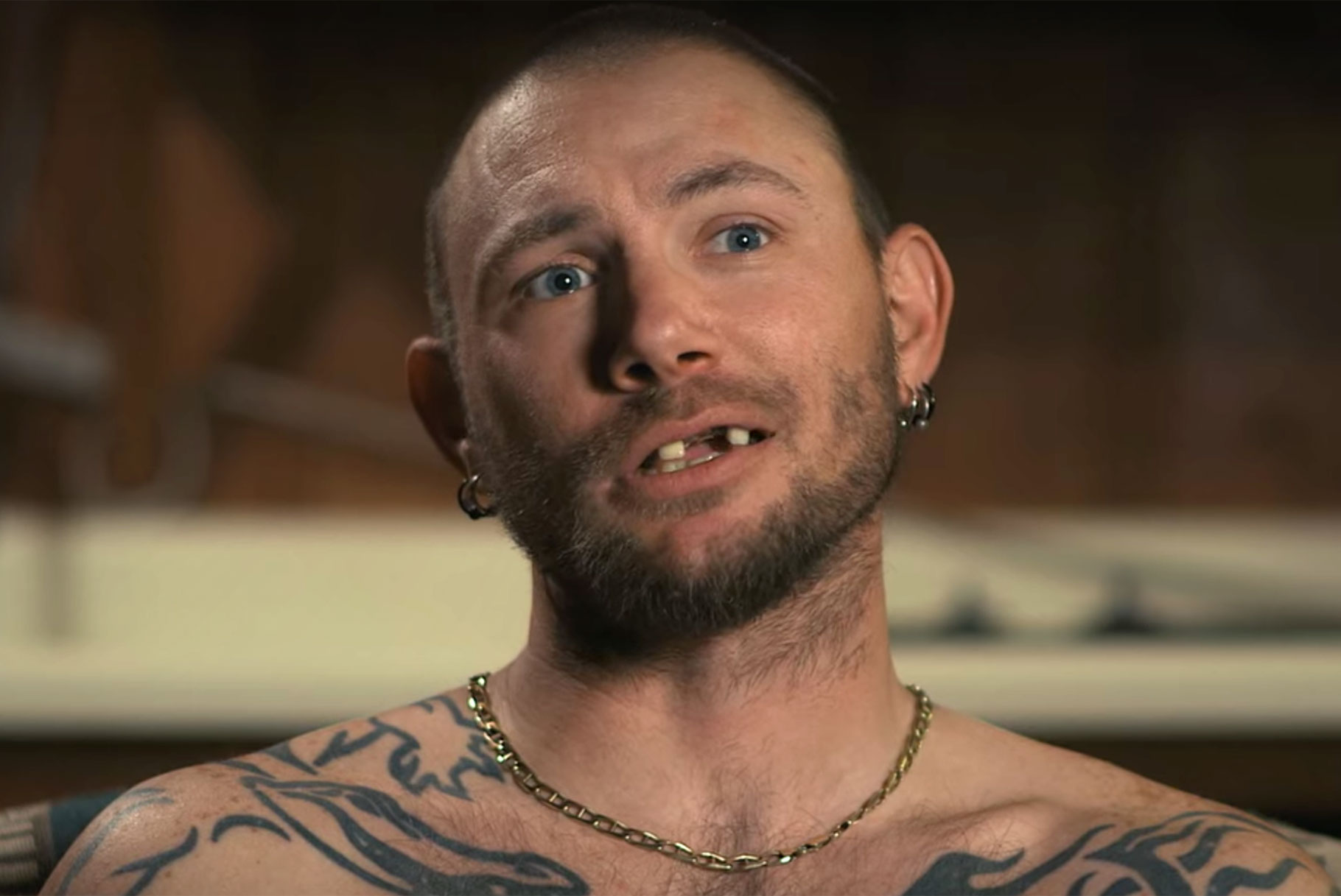 John Finlay in Netflix documentary Tiger King. A close-up interview with the shirtless Finlay reveals his heavy chest tattoos, gold chain, and missing teeth.