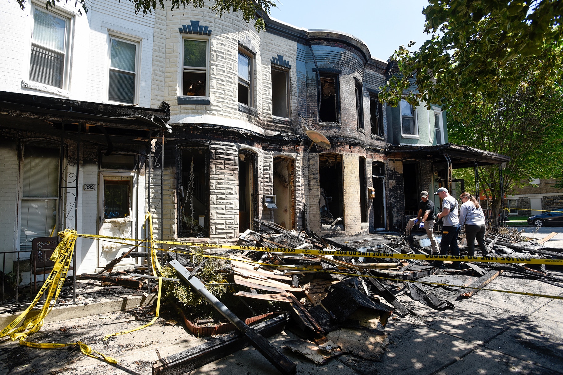 Fire investigators work at the scene of a row house fire in Baltimore