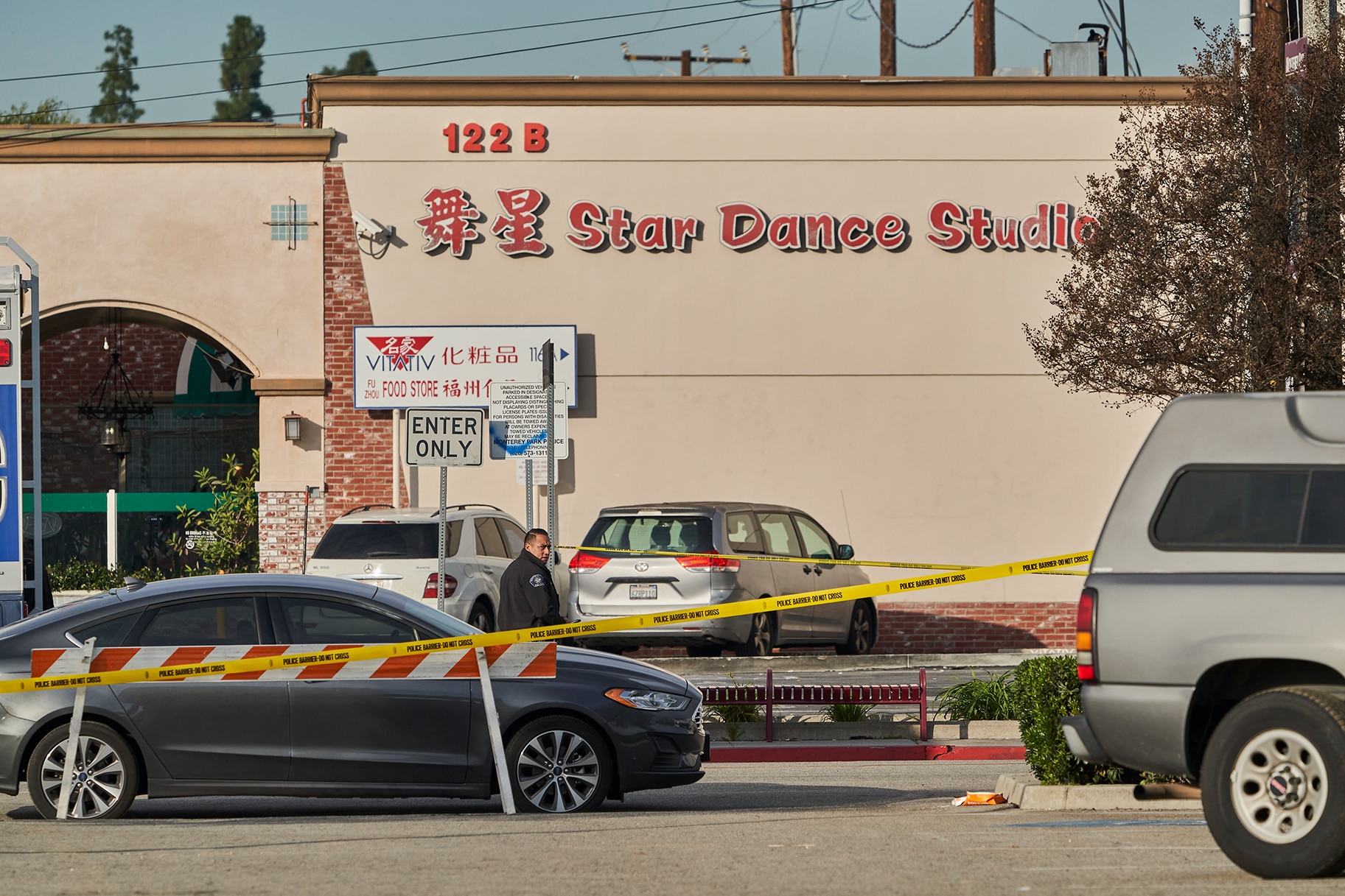 A Monterey Park police officer stands outside the Star Dance Studio