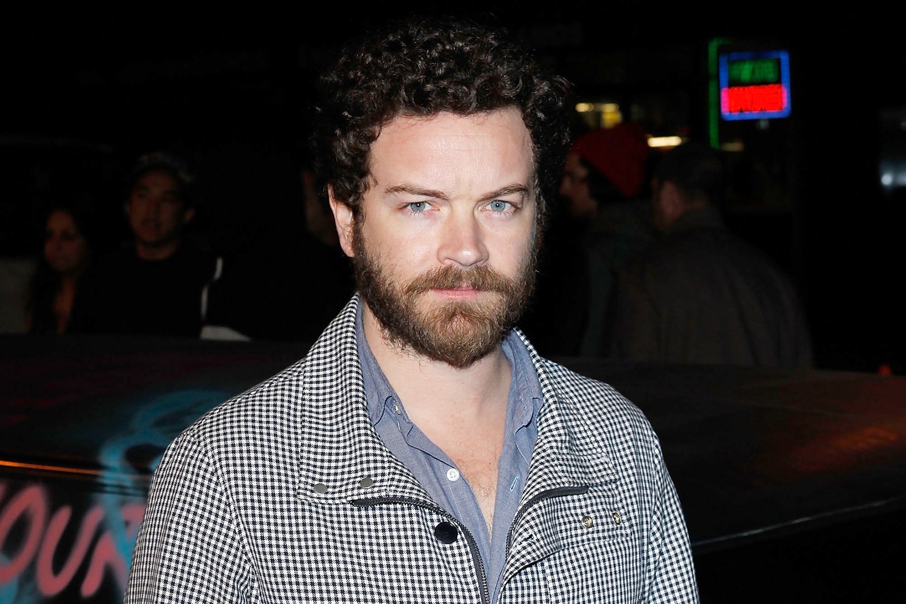 Danny Masterson wearing a black and white jacket starring into the camera