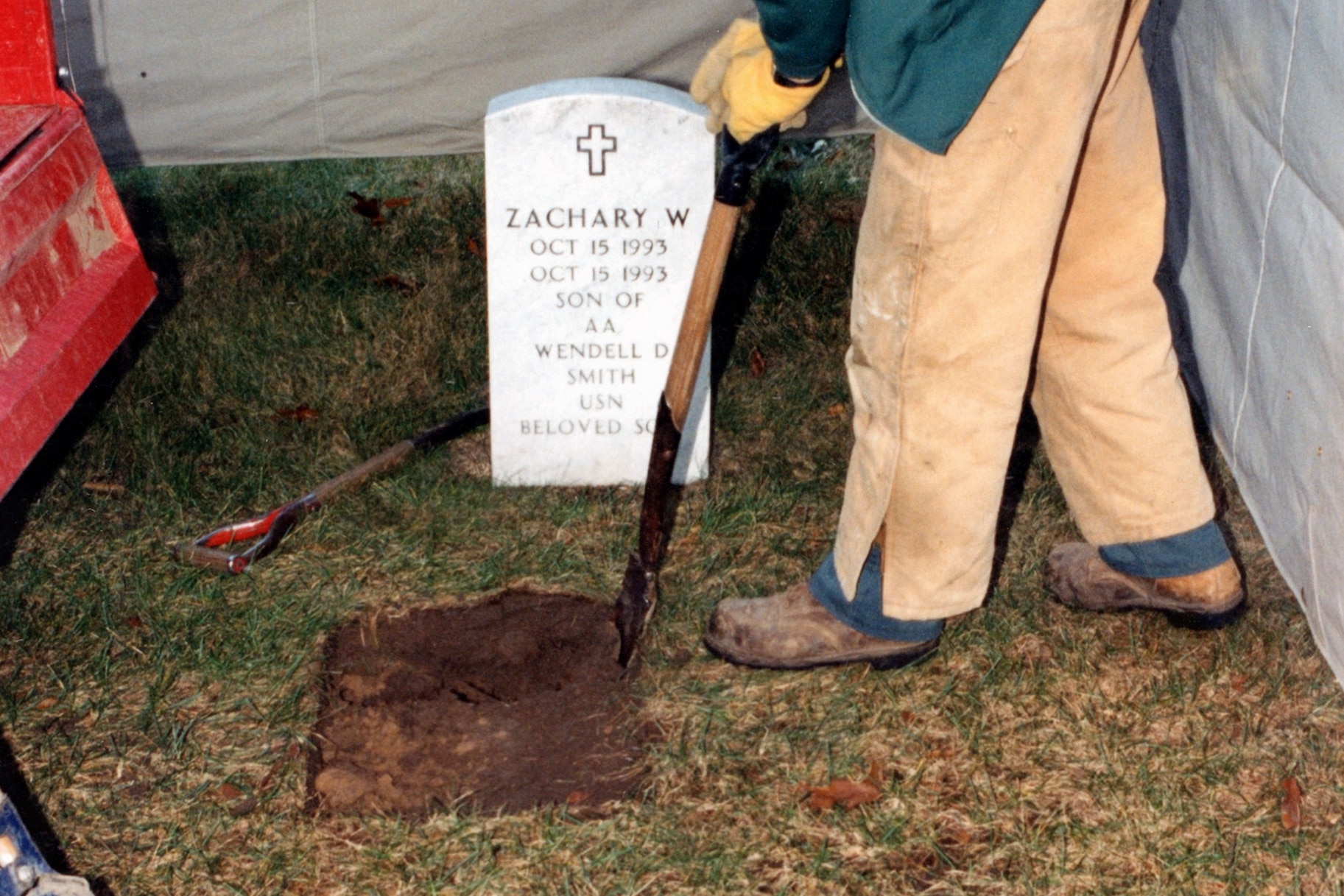A police officer digs up a grave