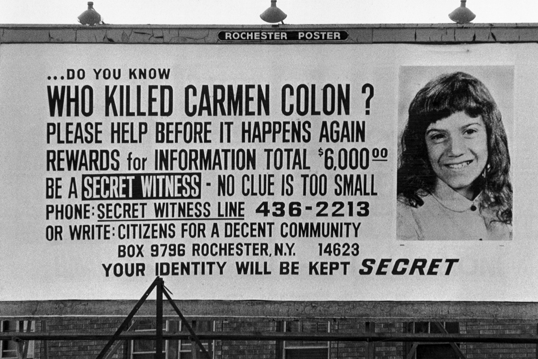A billboard asking who killed Carmen Colon
