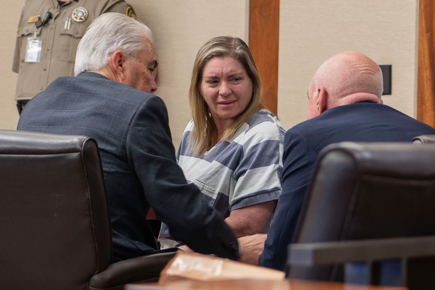 Jodi Hildebrandt speaks to two men in court.