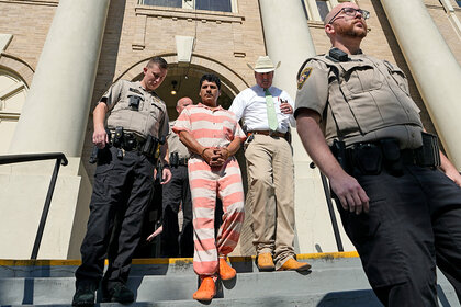 Francisco Oropeza, center, is escorted from the San Jacinto County courthouse by policemen.