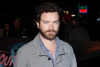 Danny Masterson wearing a black and white jacket starring into the camera
