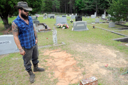 Tyler Goodson stands at the grave of his friend in Alabama