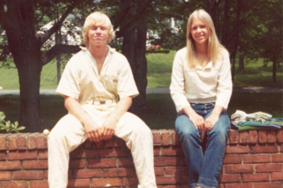 John Moxley and Martha Moxley sitting on a brick wall.