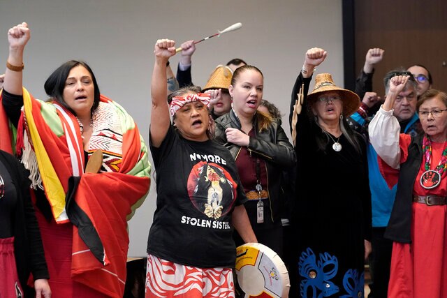 Monie Ordonia, second from left, of the Tulalip Indian Tribe, joins others in singing an honor song