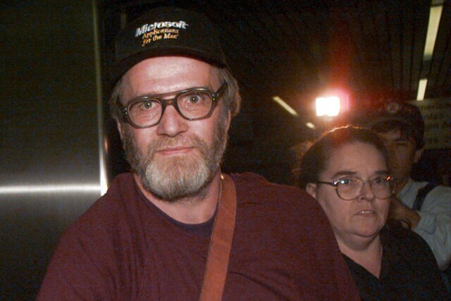 James Lewis is escorted through Boston's Logan Airport in 1995