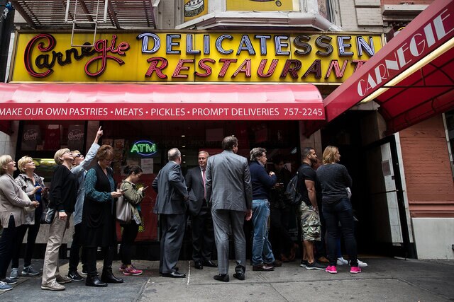 People wait in a line outside the Carnegie Deli in New York City.