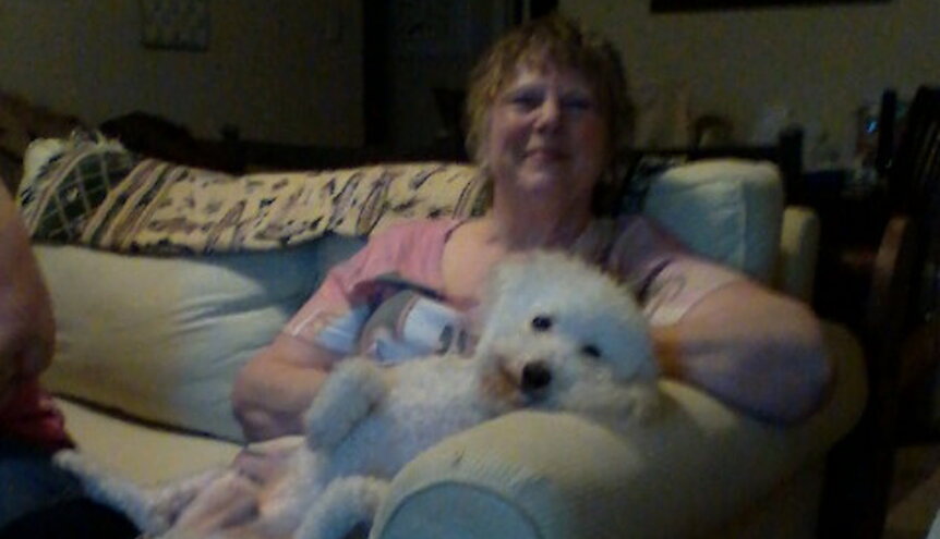 Jacquaeline “Jackie” Z. Williams posing on couch with a dog.