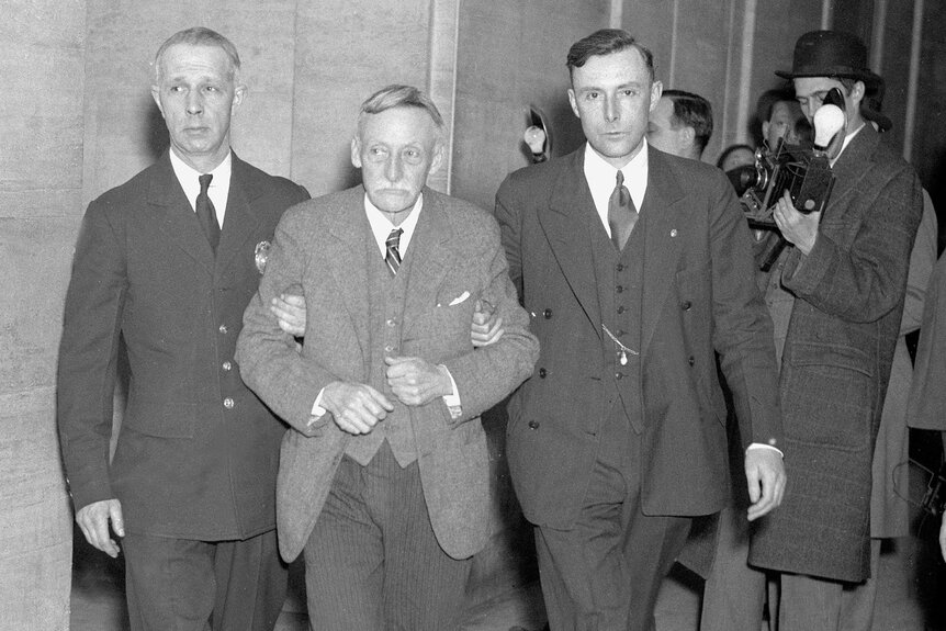 Albert Fish taken into court by two men.