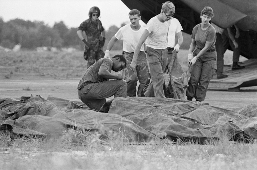 Military officials drag bodies from the jonestown mass suicide-murder